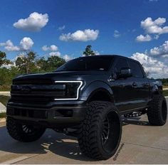 a large black truck parked on top of a parking lot