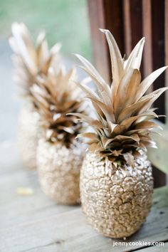 three gold pineapples sitting on top of a table