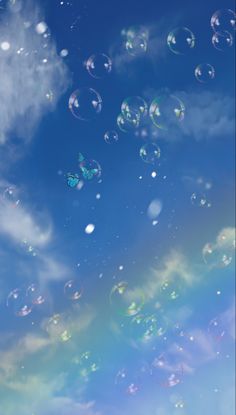 soap bubbles floating in the air on a sunny day with blue sky and white clouds