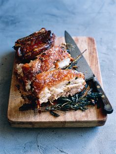 two pieces of meat on a cutting board with a knife