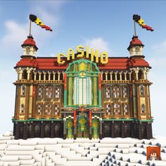 a large building made out of legos on top of snow covered ground in front of a blue sky