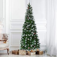 a christmas tree with presents under it in a living room next to a white wall