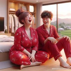 two people in red pajamas sitting on the floor next to each other, laughing and looking at each other