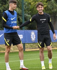 two soccer players shaking hands on the field