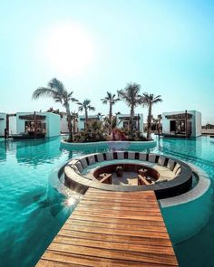 an outdoor swimming pool surrounded by palm trees