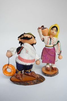 two figurines, one with a donut and the other wearing an apron