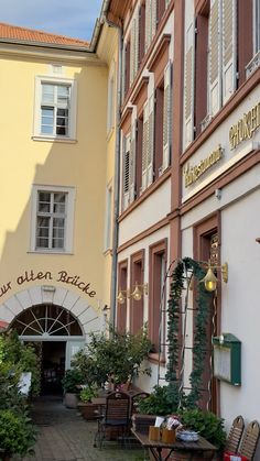 an outside view of a restaurant with tables and chairs in front of the entrance to it