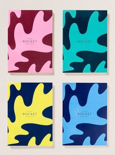 four notebooks with different designs on them, one in blue and the other in pink