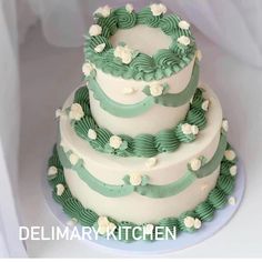 a three tiered cake with green and white decorations