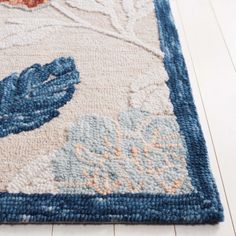 a blue and white area rug with flowers on the bottom, an orange flower in the middle