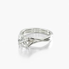 a white gold ring with a single diamond in the center and a twisted band around it