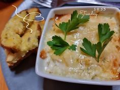 a white plate topped with food next to bread