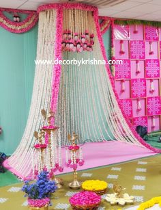 a pink and white decorated stage with flowers on the floor, chandelier and other decorations