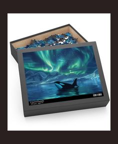 a puzzle box with an orca in the water and aurora bores behind it