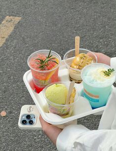 a person holding a tray with different types of food on it