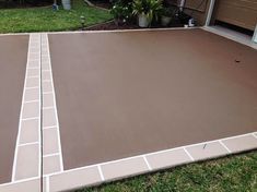 an empty backyard with some grass and plants in the back yard, next to a garage door