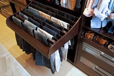 an open drawer with clothes hanging on it