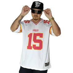 a man in a kansas football jersey is holding his hands up to his head while wearing sunglasses and a hat