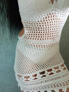 a woman wearing a white crochet dress