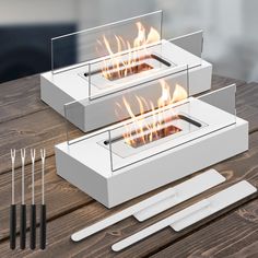 two white boxes with flames inside on a wooden table