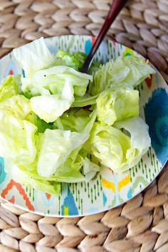 a plate with lettuce and a spoon on it