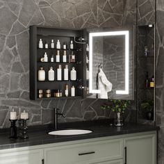 a bathroom with a sink, mirror and bottles on the wall