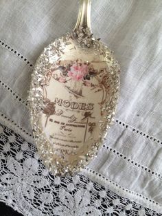 a spoon with a label on it sitting on a lace tablecloth