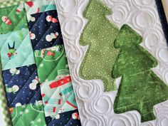 three quilted christmas trees sitting on top of each other in different colors and designs