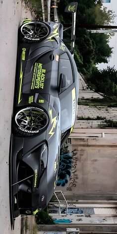 an upside down race car hanging from the side of a building