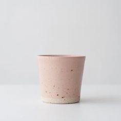 a pink cup sitting on top of a white table