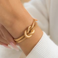 Embrace the power of simplicity with this minimalist yet striking bracelet. Crafted with meticulous attention to detail, this bracelet showcases a unique knot design that symbolizes the strength of unity and the beauty of interconnectedness. Made with a lustrous gold-tone chain, this bracelet exudes a timeless charm that is both versatile and captivating. Its sleek and polished finish adds a touch of glamour to any ensemble, making it the perfect accessory for both casual and formal occasions. Its adjustable length ensures a comfortable fit for all wrist sizes, while the secure clasp guarantees peace of mind during wear.Weight: 13.4 gMaterial: CopperBracelet Size: 140+50 mmPlating Color: Yellow Gold Gold Knot Bracelet, Grunge Jewelry, Trending Bracelets, Bracelet Knots, Snake Chain Bracelets, Snake Bracelet, Chunky Jewelry, Knot Bracelet, Estilo Punk