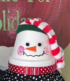 a snowman wearing a red and white hat with polka dots on it's head