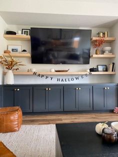 a living room filled with furniture and a flat screen tv mounted above it's entertainment center