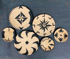 four black and white woven coasters with geometric designs on the top one has an ornament in the middle