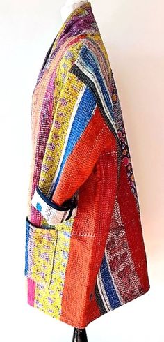 This exceptional multi color patchwork jacket is part of our new specialty collection which redefines handcrafted artisan fashion. This expertly engineered mixed print jacket is made from vintage luxe cotton sari material. Hand embroidered with kantha stitches. It has a wide, loose angled shape with side pockets on each side. Long sleeves may be rolled or folded based on your desire. Jacket is to be worn open. This jacket is fully reversible. The reverse print compliments each side, infusing bright and bold multi colored prints, and then reversing to soft pastels. Dramatic presentation infused with European flare. This jacket is the traditional kimono cut, considered a classic that will be worn and appreciated for years to come. Made with the highest caliber of materials and exhibits sever Multicolor Outerwear With Woven Motifs For Fall, Festive Multicolor Patchwork Outerwear, Traditional Long Patchwork Outerwear, Bohemian Multicolor Outerwear With Woven Motifs, Festival Multicolor Embroidered Patchwork Outerwear, Multicolor Embroidered Patchwork Cotton Outerwear, Traditional Patchwork Cotton Outerwear, Luxury Multicolor Patchwork Outerwear, Traditional Multicolor Block Print Outerwear