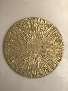 a gold plate sitting on top of a white table next to a black and white wall