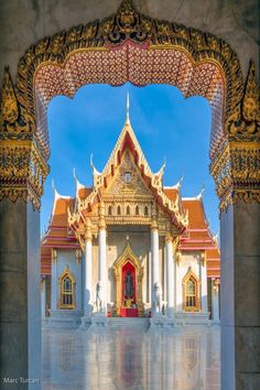 the entrance to an ornate building with gold and red decorations on it's sides