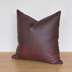 a brown leather pillow sitting on top of a wooden table