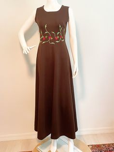 This is a maxi dress from Miss Ludi boutique in Madrid, Spain.  The dress is sleeveless and unlined with back zipper.  The waistline is embellished with applique flowers and embroidered vines.  Some stretch, check measurements carefully.   Measurements taken with dress laying flat and doubled where appropriate. In order to determine fit we recommend comparing measurements with an item that fits you well. Length 54 inches Underarm to underarm 34 inches Waist 28 inches Hips 38 inches Always happy Brown Fitted Maxi Length Dress, Fitted Brown Floor-length Maxi Dress, Brown Floor-length Maxi Dress For Evening, Spring Brown Long Maxi Dress, Brown A-line Maxi Dress For Spring, Fitted Sleeveless Maxi Dress With Floral Embroidery, Fitted Vintage Brown Maxi Dress, Retro Fitted Sleeveless Maxi Dress, Retro Sleeveless Brown Dress