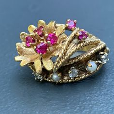 We take pride in finding unique , quality ~ Antique /Vintage jewelry pieces which are carefully hand picked by us so that you can add them to your treasure/ collection or gift to someone you love ~ We try to add plenty of items every week and have been selling online for more then 10 years . Vintage ~ 14kt yellow gold ~ Diamond ~ rubies ~ seed pearl ~ Cocktail /dinner ring ~ There are 6 small prong set faceted rubies , 3 diamonds and two seed pearls with applied wire work ~ Very well made ring . Heirloom Multi-stone Pearl Ring For Anniversary, Vintage Diamond Ruby Ring, Vintage Pink Jewelry For Anniversary, Pink Vintage Jewelry For Anniversary, Heirloom Multi-stone Pearl Ring Gift, Heirloom Multi-stone Pearl Ring As Gift, Vintage Ring Jewelry For Vintage Events, Gold Multi-stone Pearl Ring In Fine Jewelry Style, Vintage 14k Gold Pink Jewelry