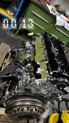 an image of a car engine being worked on in a garage with tools and other items