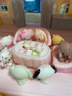 there are many toys on the table in this playroom setting, including an elephant and other animal figurines