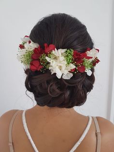 the back of a woman's head with flowers in her hair, wearing a dress