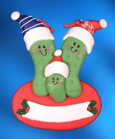 an ornament shaped like two peas wearing santa hats