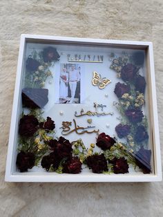 a photo frame with flowers and a butterfly in the middle on a furnishing