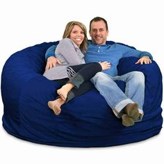 a man and woman sitting on a bean bag chair