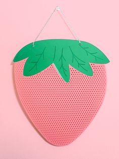 a paper strawberry hanging on a pink wall