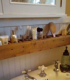 a bathroom sink with soap, toothbrushes and other items on the shelf above it