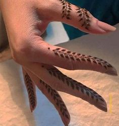 a woman's hand with hennap on it and two fingers that have leaves painted on them