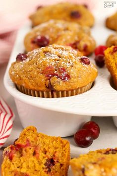 cranberry orange muffins on a white plate next to fresh cranberries